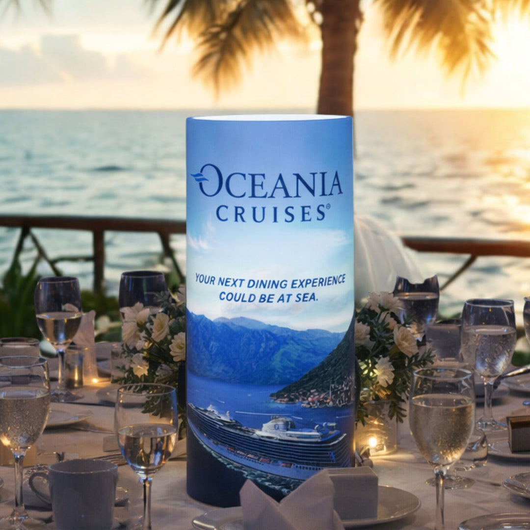 Oceania Cruises promotional sign on a table with a scenic background